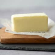 Stick of unwrapped butter on a cutting board