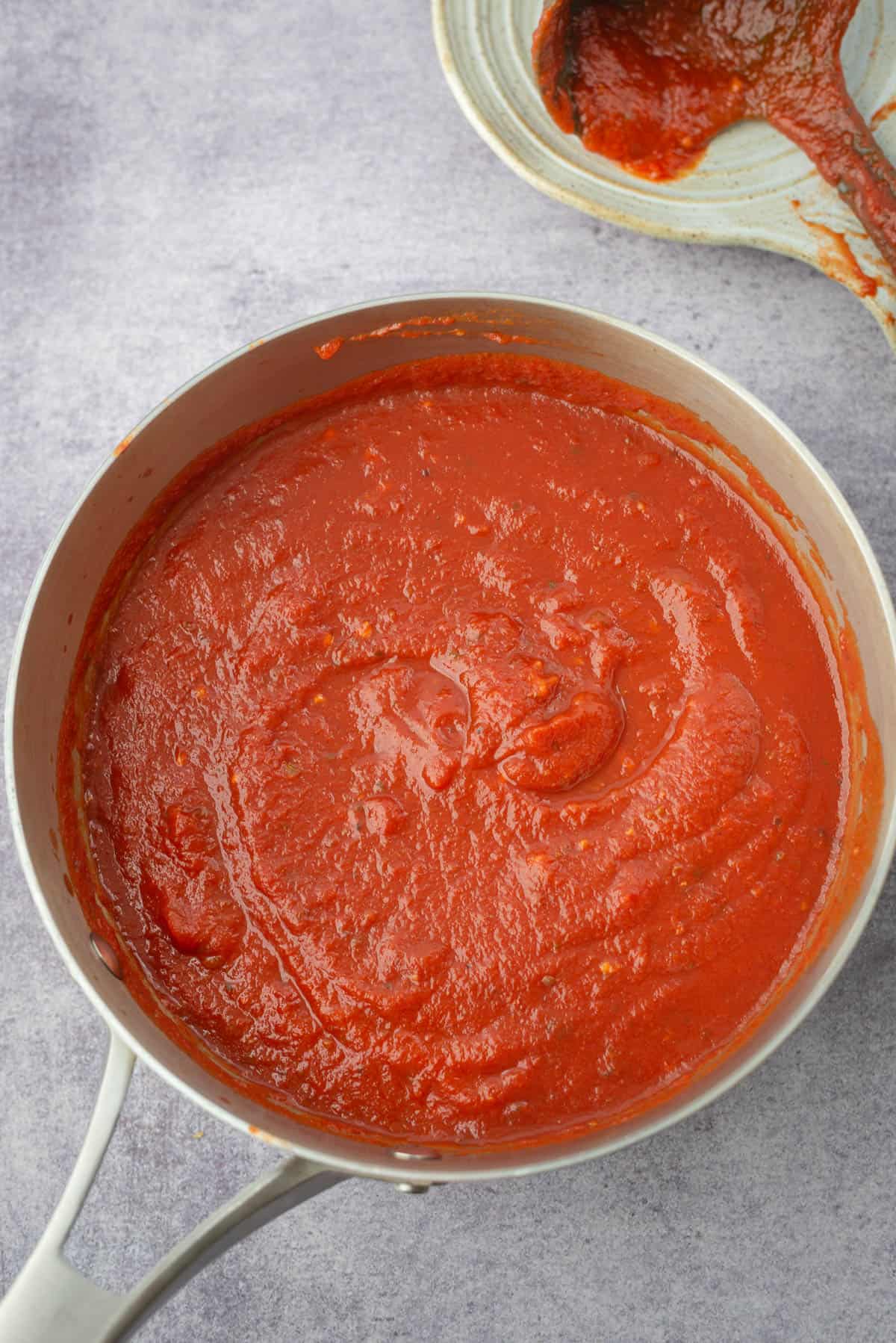 Pan of Marinara Sauce with ladle in background 