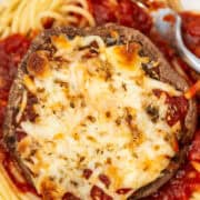 Close up of Portobello Mushroom Parmesan on plate with pasta