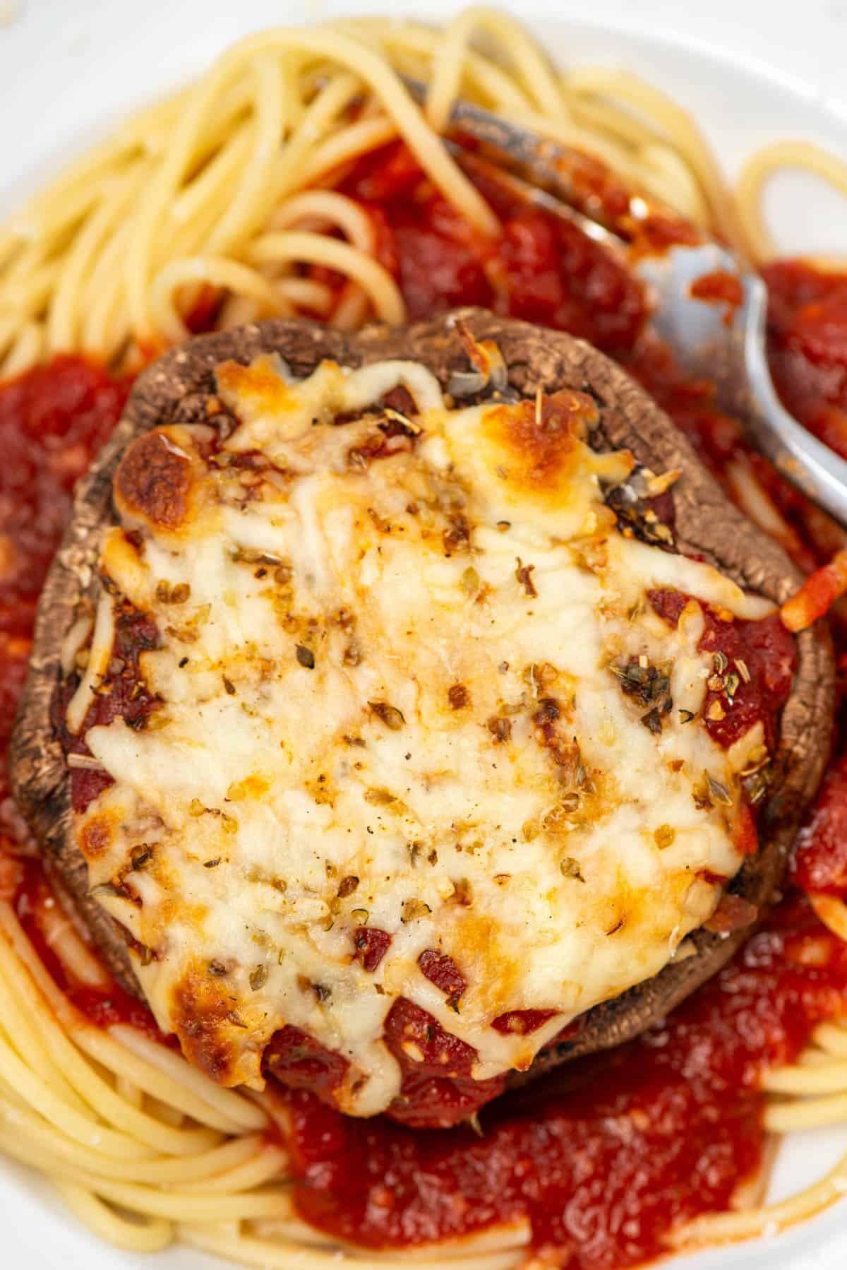 Close up of Portobello Mushroom Parmesan on plate with pasta