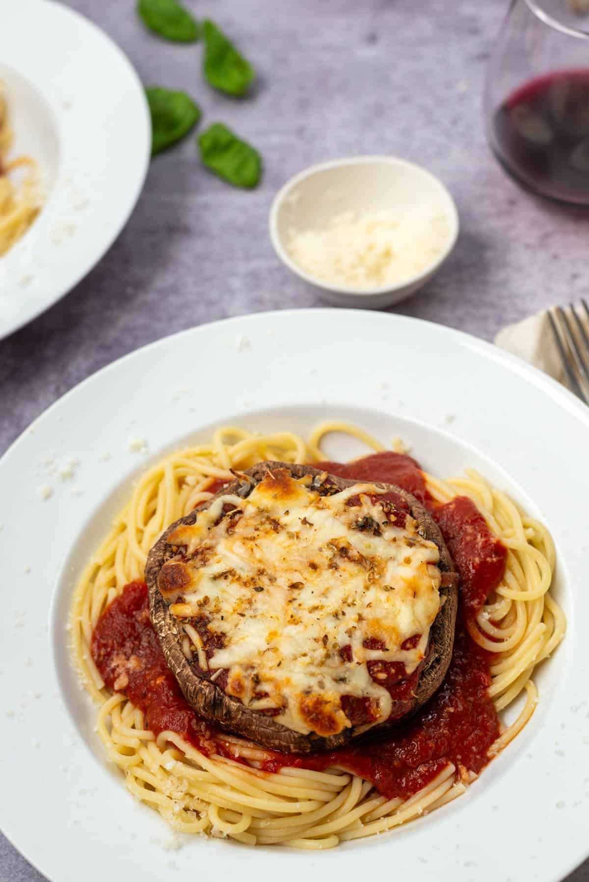 Cooked portobello mushroom parmesan on pasta on a plate