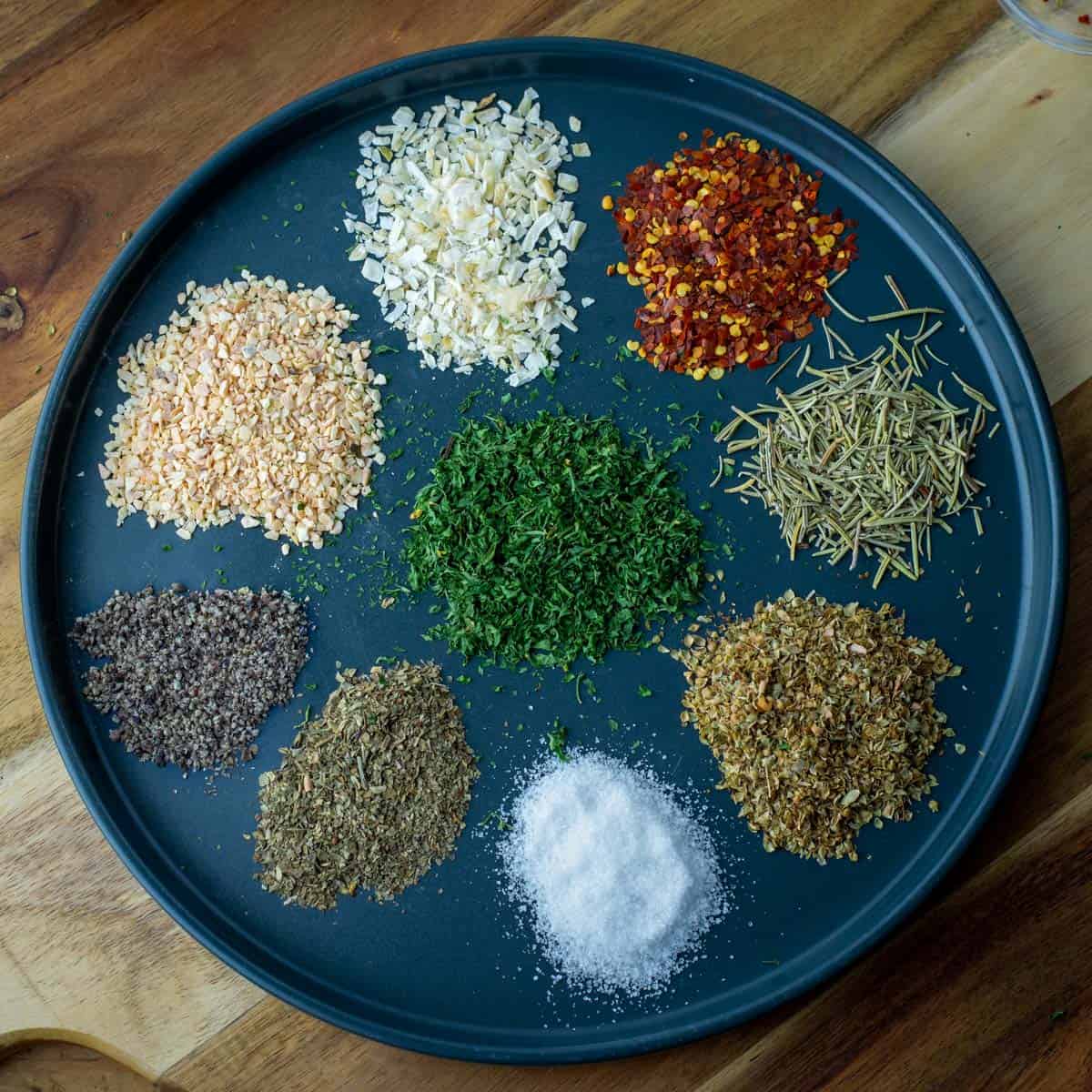 Plate with 9 different spices used to make bread pepper seasoning