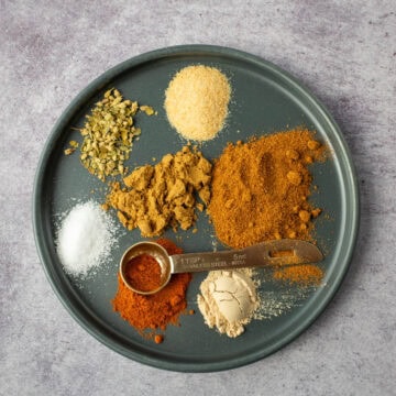 Taco seasoning spices separated on plate with measuring spoon