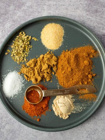 Taco seasoning spices separated on plate with measuring spoon