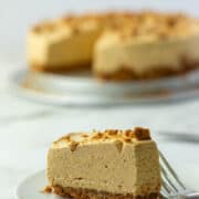 Slice of no bake pumpkin cheesecake in front of whole cheesecake