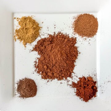 5 spices needed to make pumpkin pie spice separated on a plate: cinnamon, cloves, ginger, nutmeg and allspice