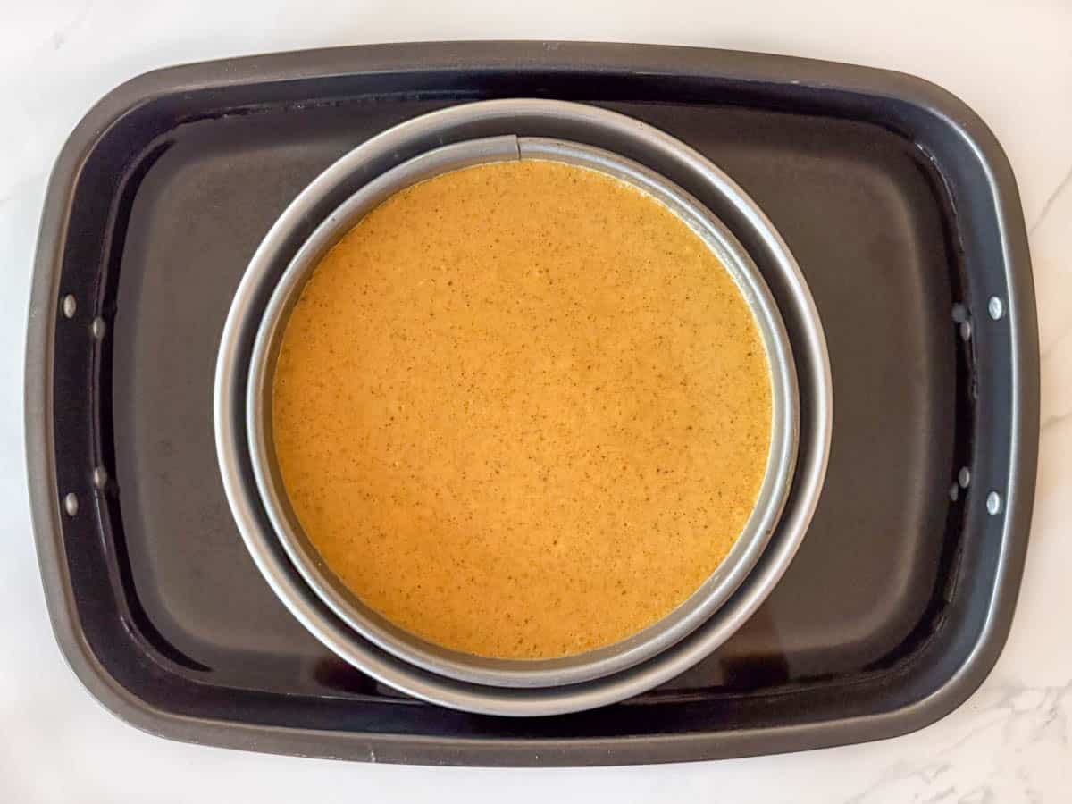 Baked cheesecake still in springform pan in water bath