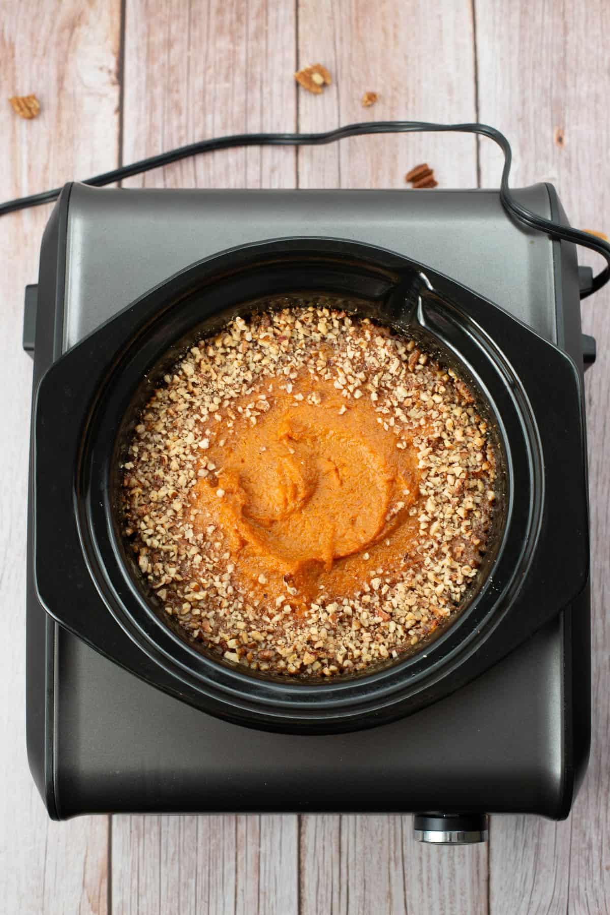 Bourbon Sweet Potatoes garnished with pecans in a Crockpot