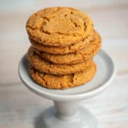 5 chewy ginger molasses cookies stacked on a small pedestal