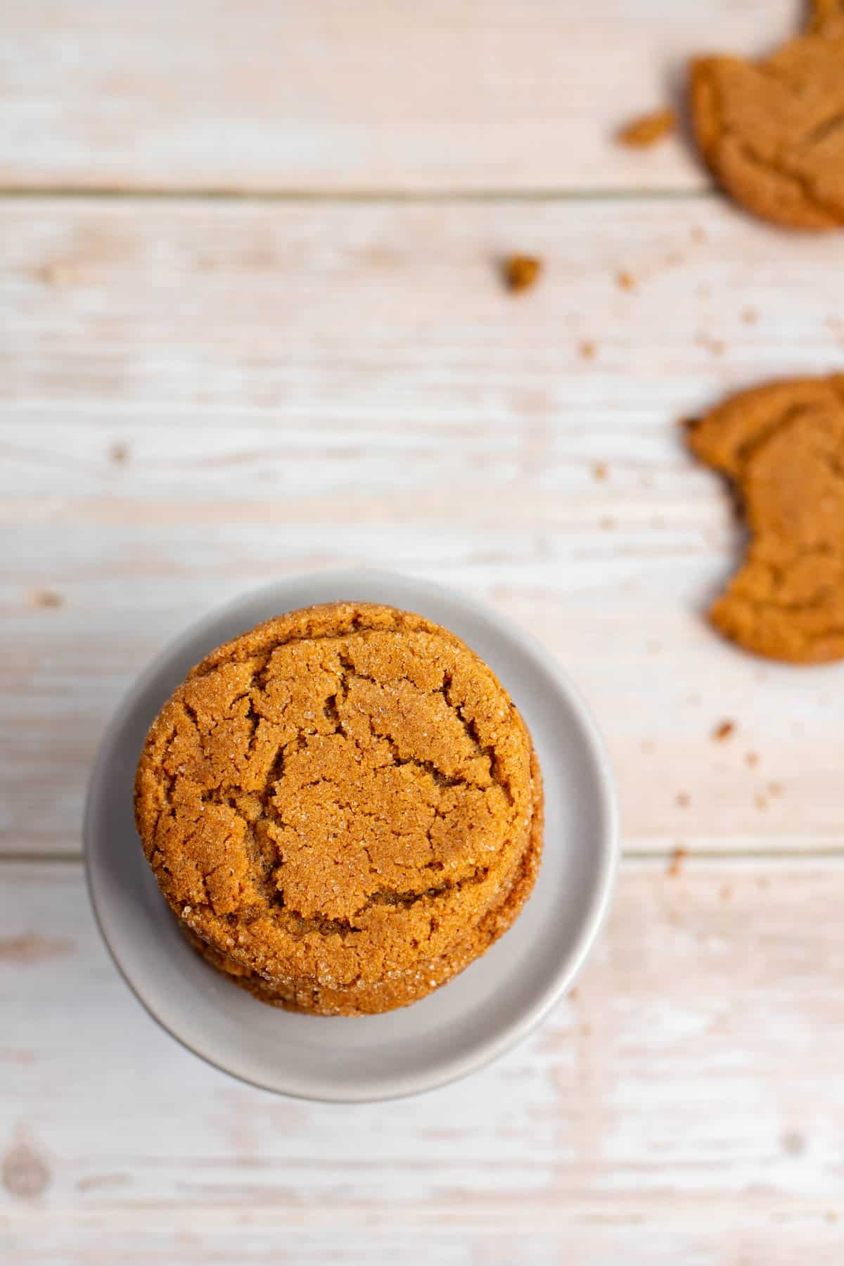 top view of stack of chewy ginger molasses cookies with some additional cookies in the background