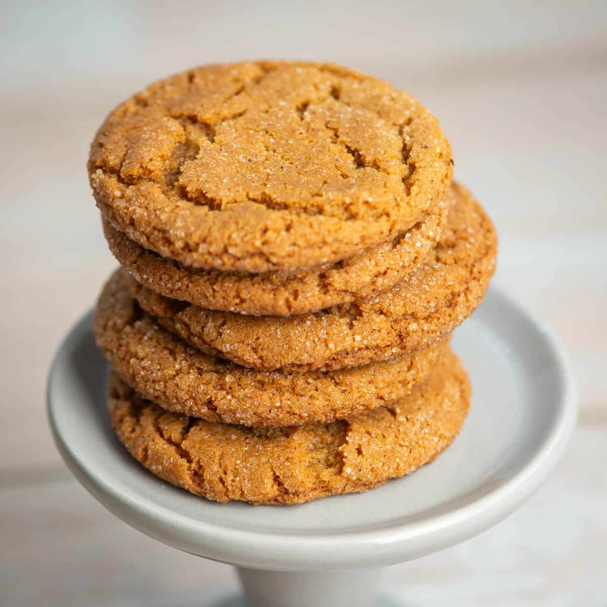 Close up photo of stack of chewy ginger molasses cookies on a pedestal