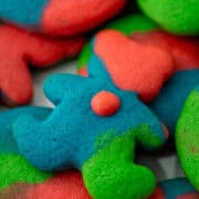 Close up photo of teddy bear colored cookie dough sugar cookie on top of other colored sugar cookies