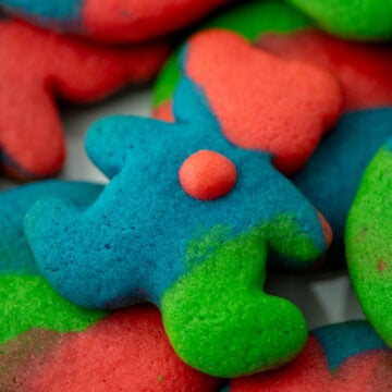 Close up photo of teddy bear colored cookie dough sugar cookie on top of other colored