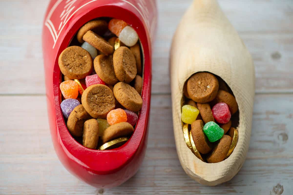 Close up photo of Dutch wooden shoe filled with peppernut cookies, spiced gum drop candies and gold coins with