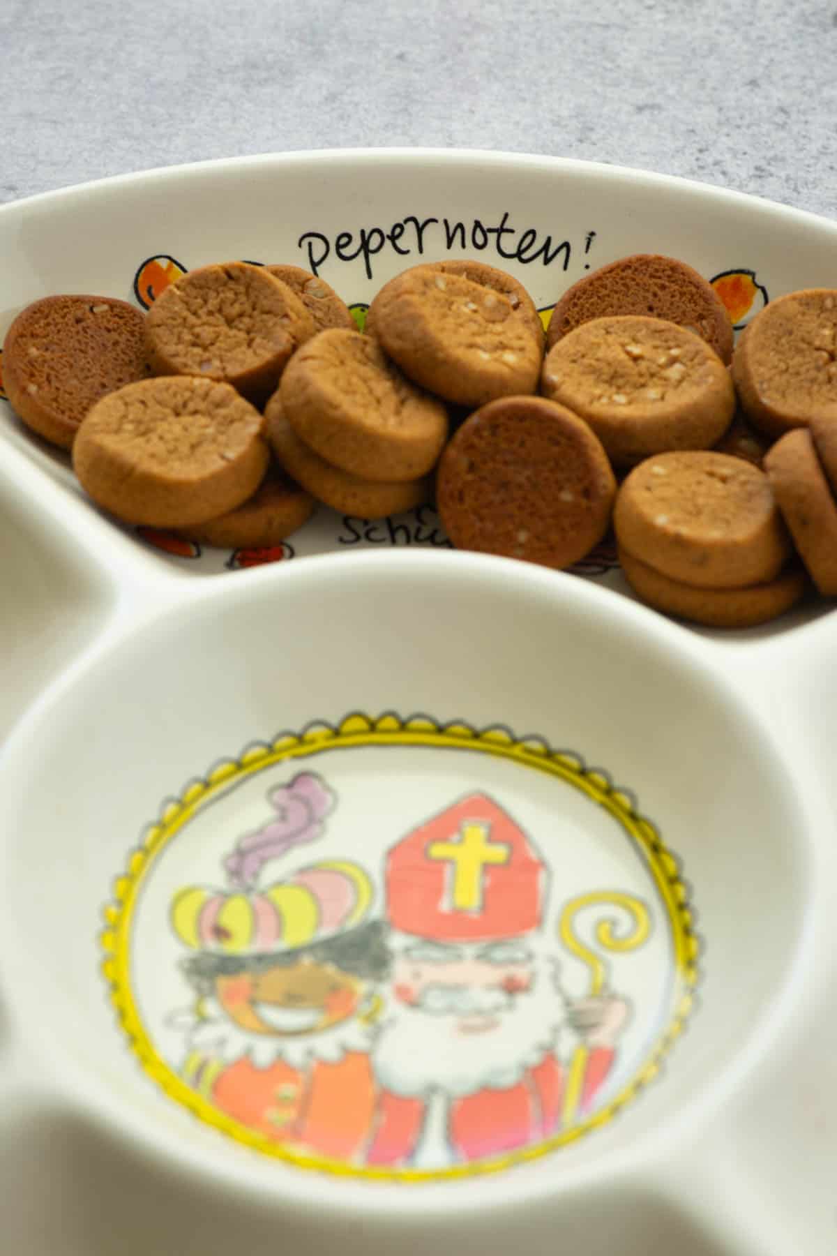 Bowl of cookies with Pepernoten written on back of bowl and photo of Sinterklaas