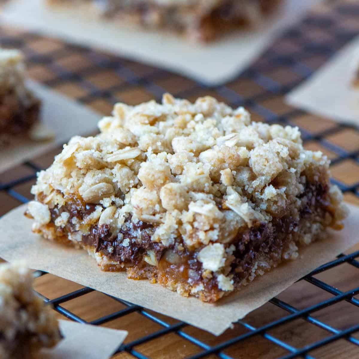 Photo of Carmelitas cookie bar on parchment paper on top of cooling rack