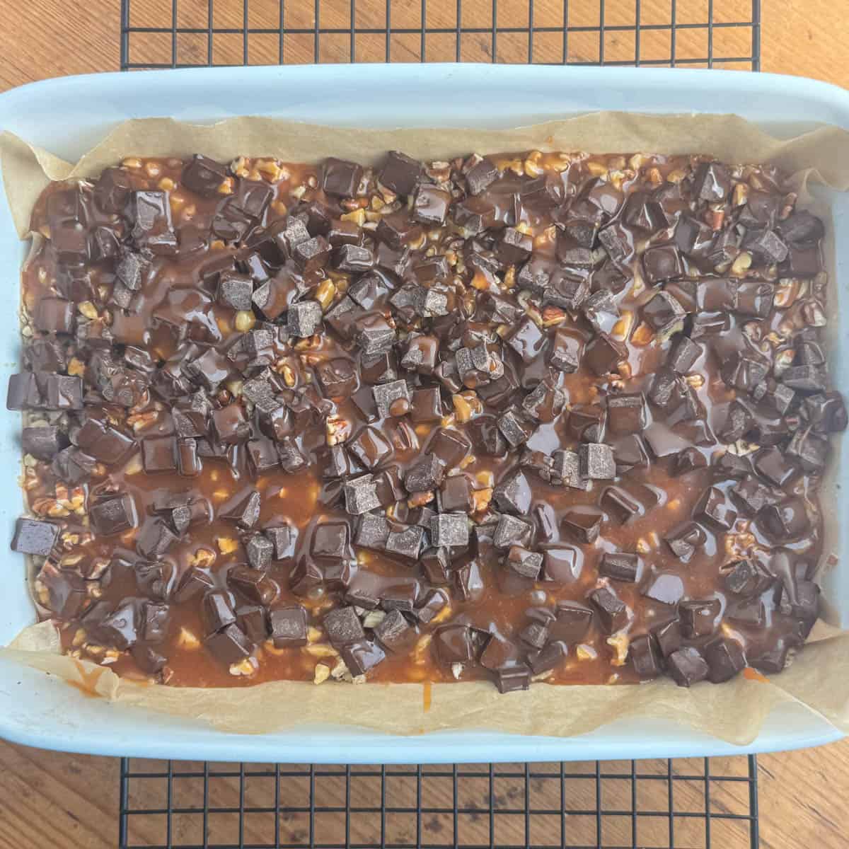 Carmelitas recipe process shot #5 of crust with pecans, walnuts, chocolate chunks and caramel layered on top