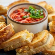 Close up of appetizer size pieces of baked grilled cheese sandwiches with tomato dipping sauce