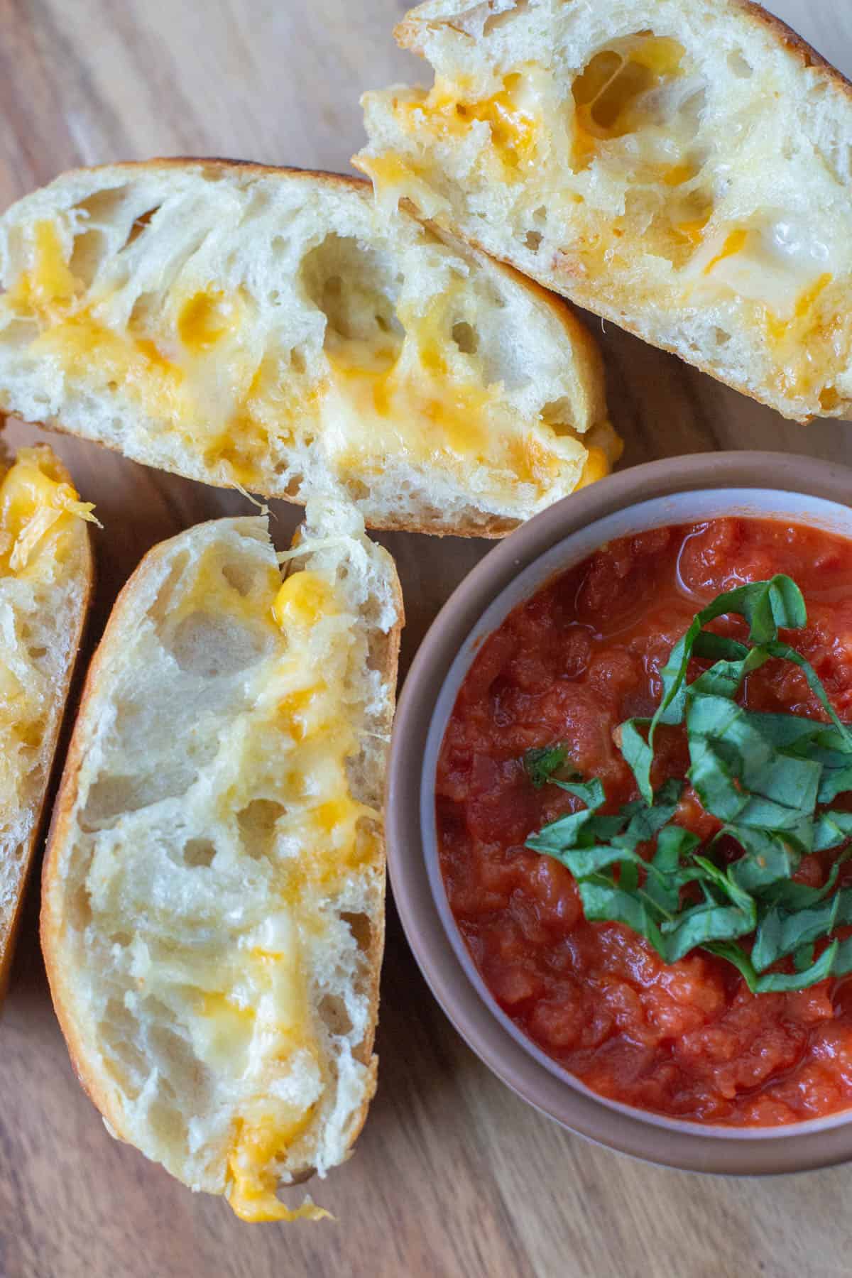 Close up grilled cheese on a ciabatta bun with tomato dipping sauce on the side