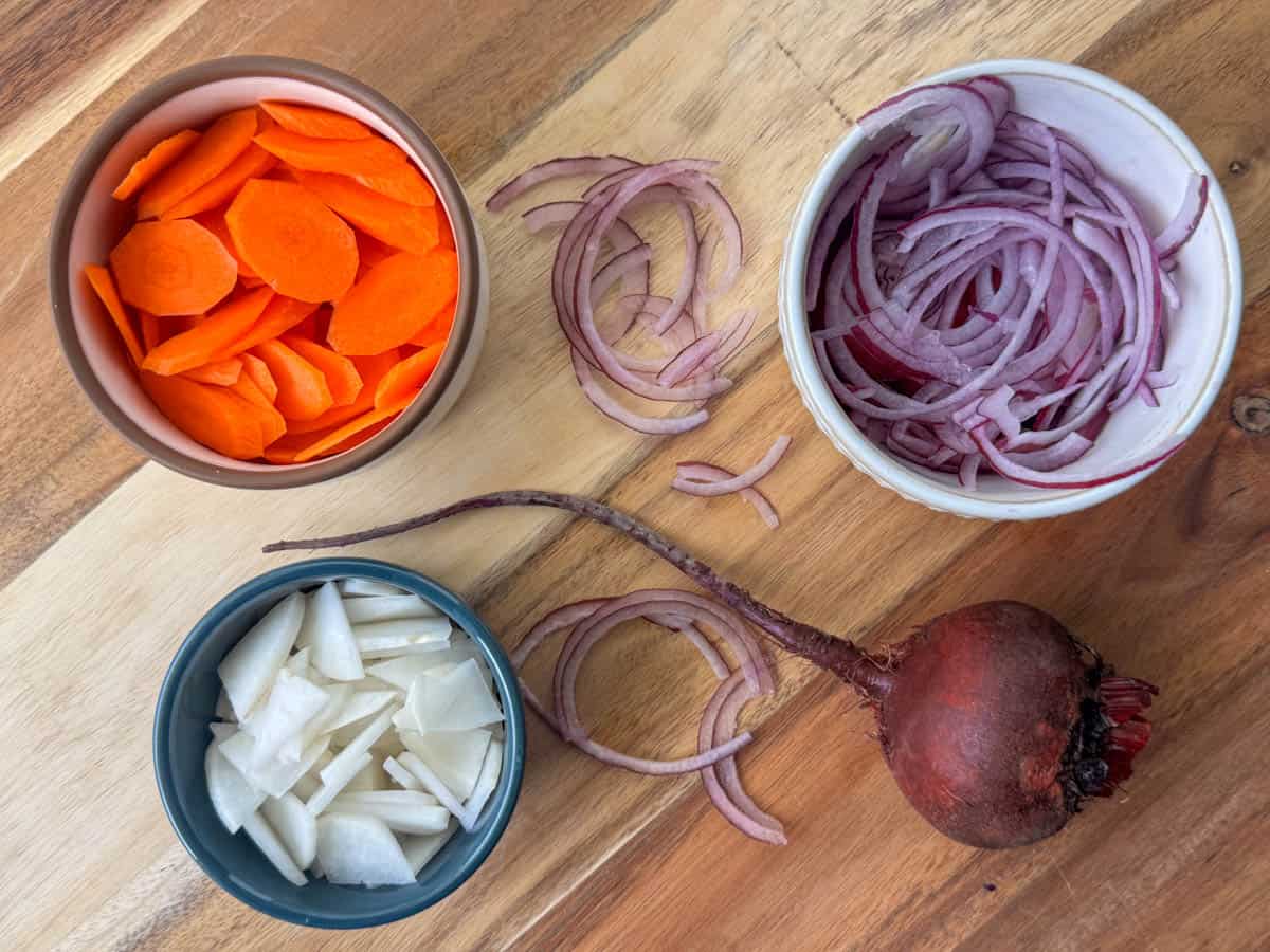 Photo of root vegetables choices for making a salad: sliced carrot, sliced red onion, sliced turnips and beets