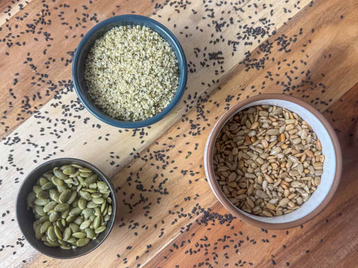 Photo of seed choices for making a salad: pepitas, sunflower seeds, hemp seeds and sesame seeds