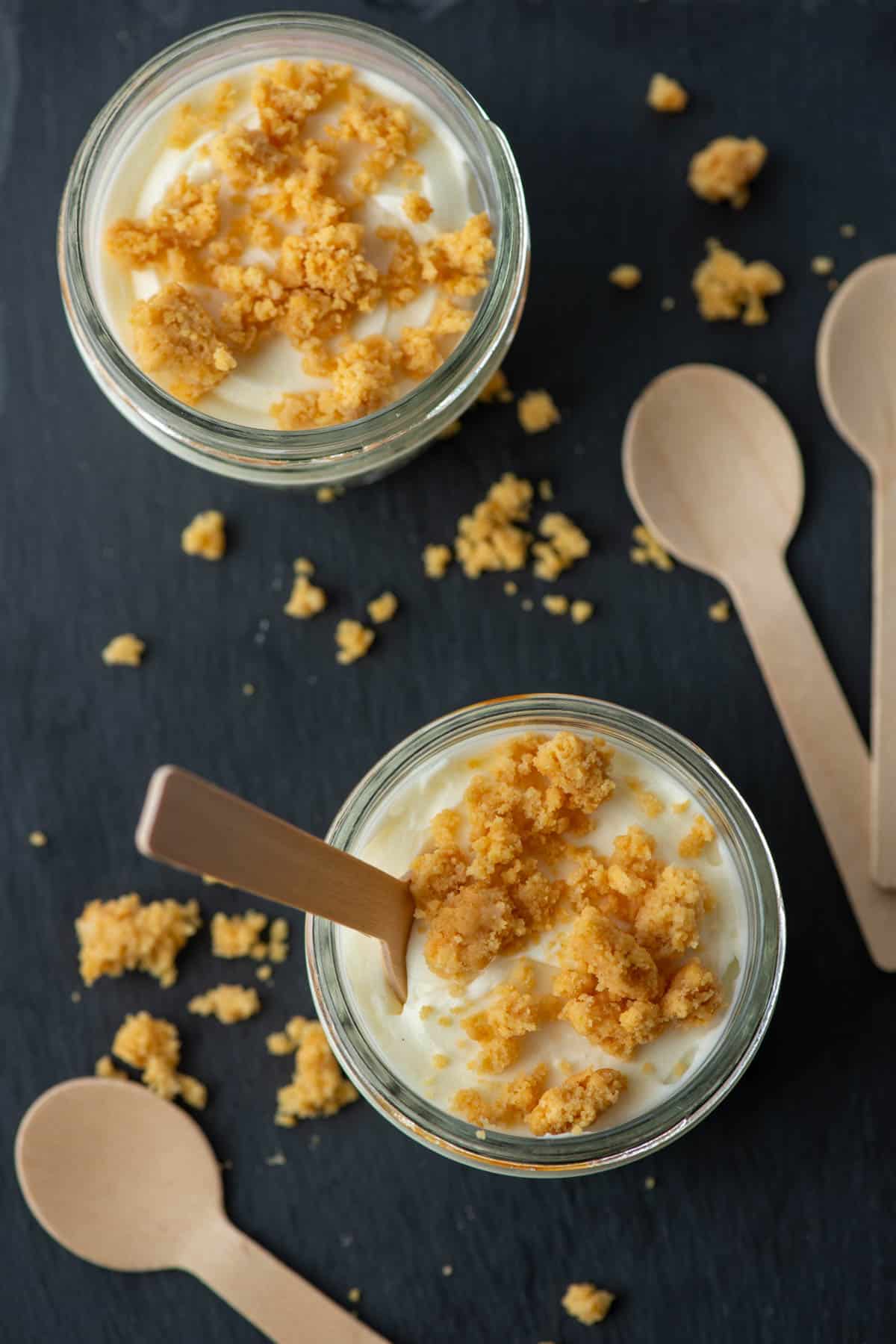 Close up photo of two single serving jars of keto mini lemon cheesecake