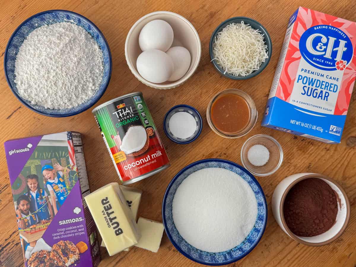 Ingredients needed to make Samoas cupcakes: Samoas cookies, cake flour, cocoa powder, white sugar, salted butter, coconut milk, baking soda, salt, coconut flakes, salted caramel sauce and powdered sugar