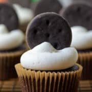 Photo of many Thin Mints Cupcakes on a cooling rack with a box of Thin Mints cookies in the background