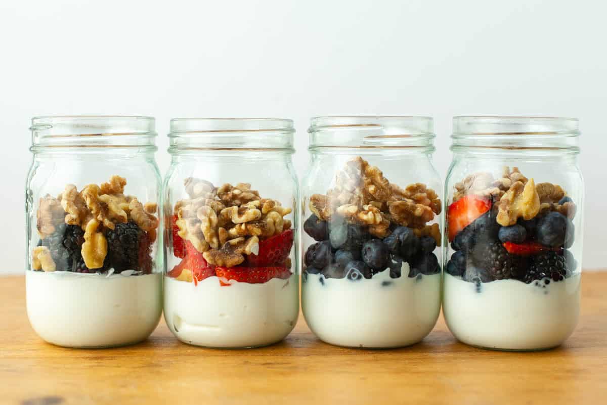 Side view of four jars of berry yogurt parfaits