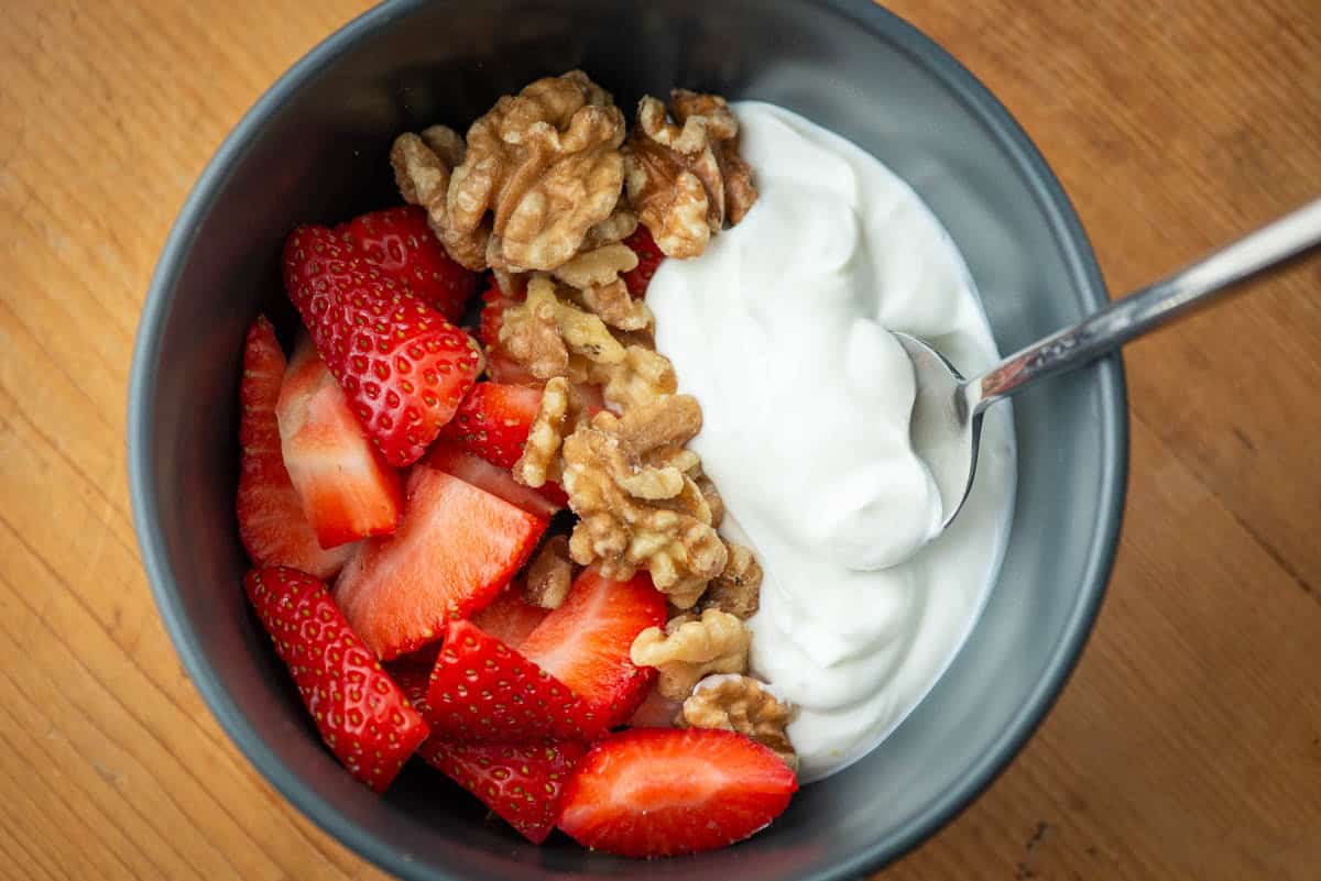 Overhead view of a strawberry, walnuts and greek yogurt bowl