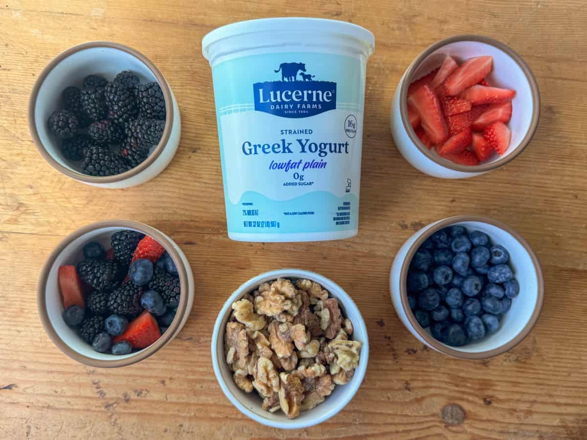 Ingredients needed to make yogurt berry parfaits: blueberries, blackberries, strawberries, walnuts and greek yogurt