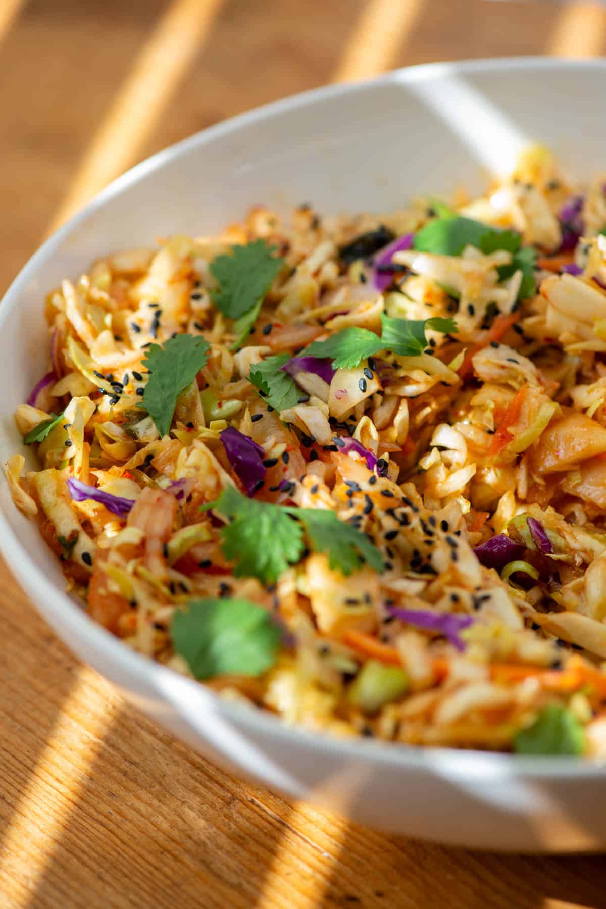 Kimchi slaw in a bowl with light rays shining on the bowl