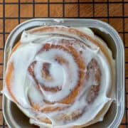 Overhead close up photo of a cinnamon roll in a mini square baking cup.