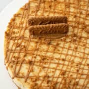 Overhead view of partial Biscoff Cookie Butter cheesecake decorated with cookie butter drizzle and crumbled Biscoff cookies