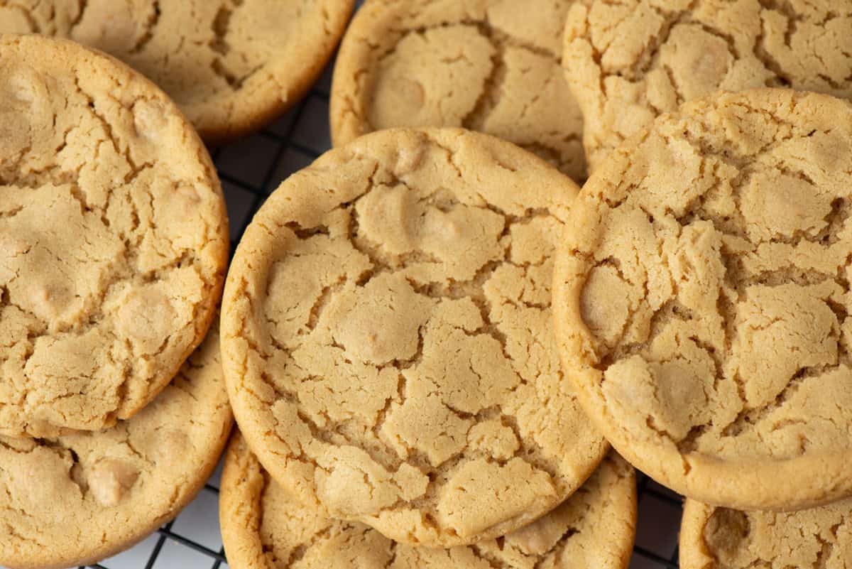 Close up photo of giant peanut butter cookies randomly stacked on a cooling rack