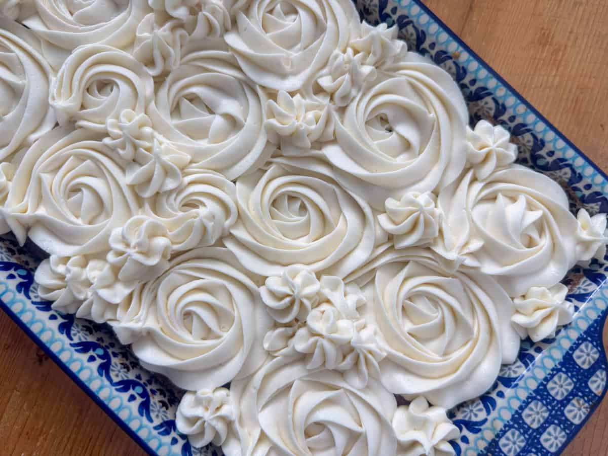 Overhead photo of carrot cake with cream cheese frosting piped on in rosettes