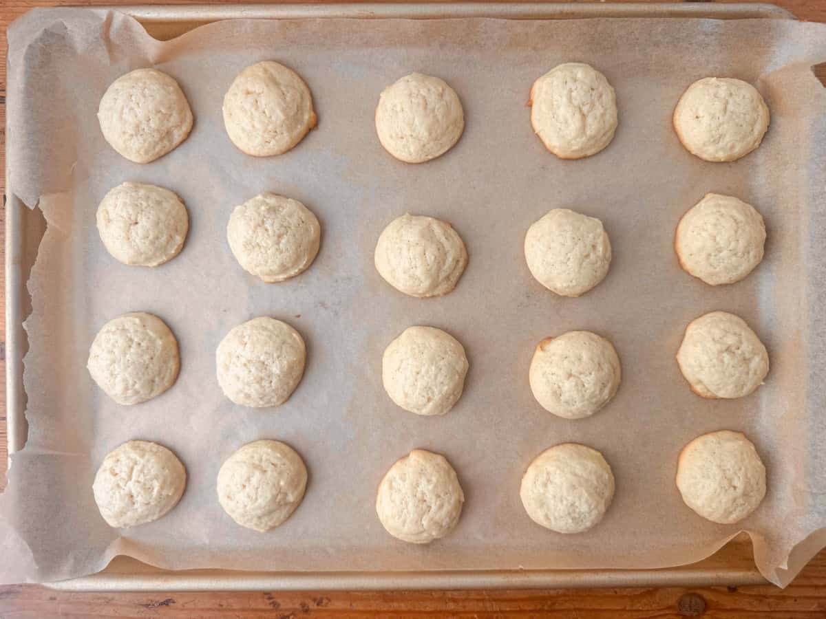 Overhead view of cooked sour cream sugar cookies on a cookie sheet