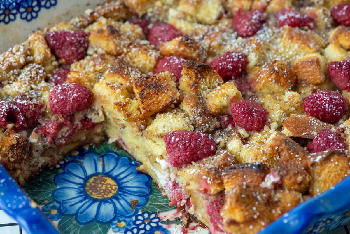 Close up photo of bake raspberry brioche French toast in the baking pan with a few slices missing