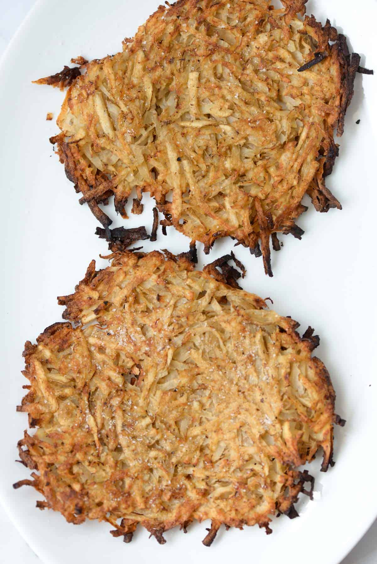 Two grilled hash browns on a serving platter