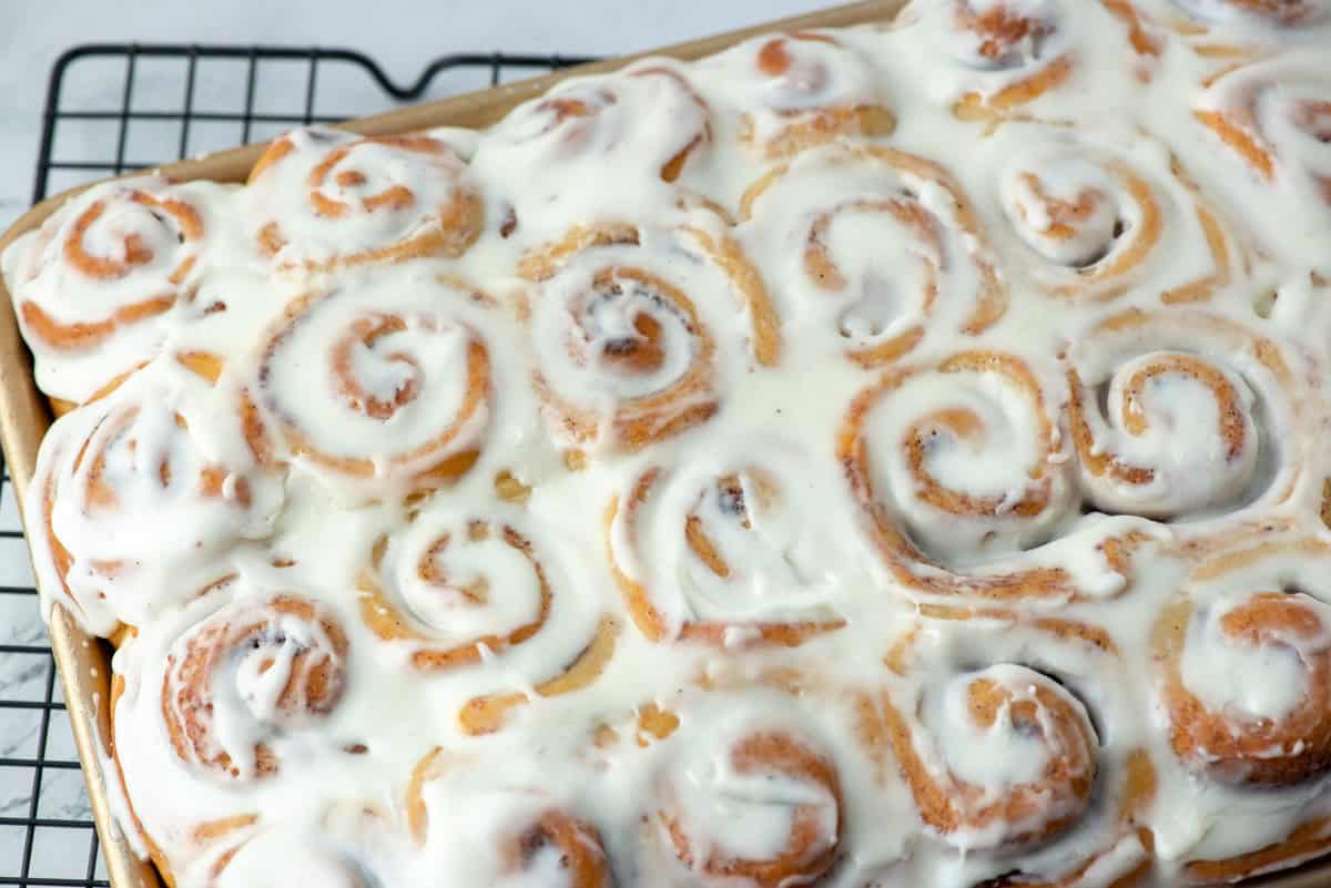 Overhead view of a partial quarter sheet baking sheet of mini cinnamon rolls