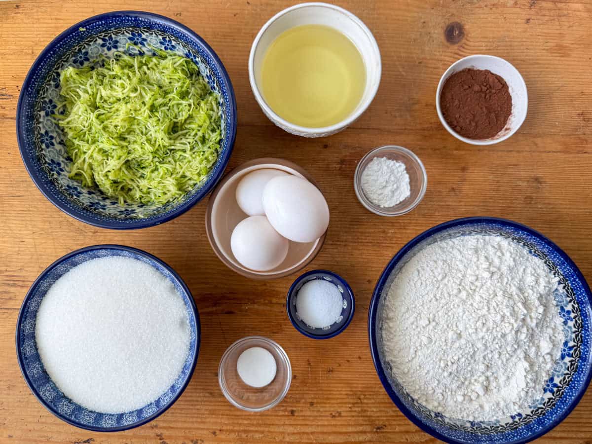 Ingredients needed to make zucchini cupcakes: all purpose flour, white sugar, finely grated zucchini, eggs, neutral oil, cinnamon, baking powder, baking soda and salt