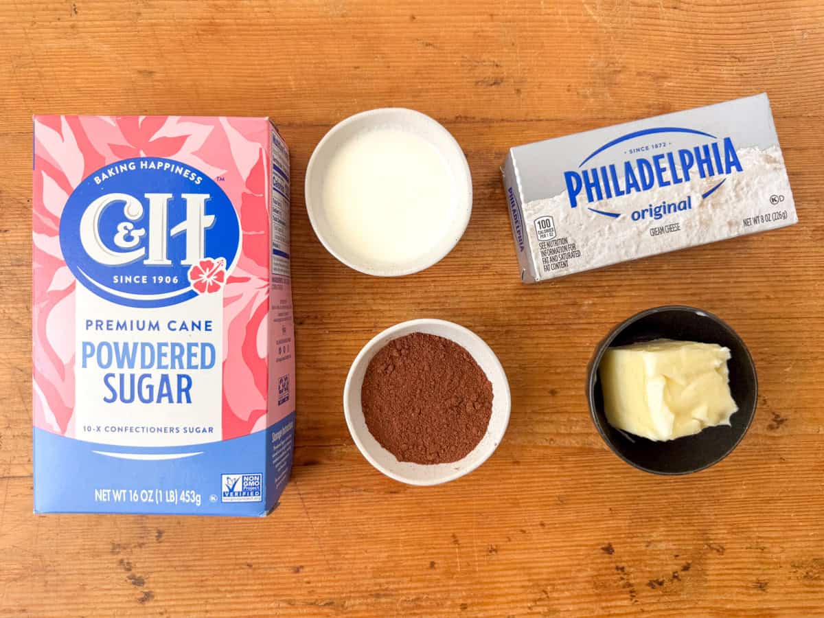 Ingredients needed to make cinnamon cream cheese frosting: powdered sugar, cream cheese, butter, cinnamon and heavy whipping cream