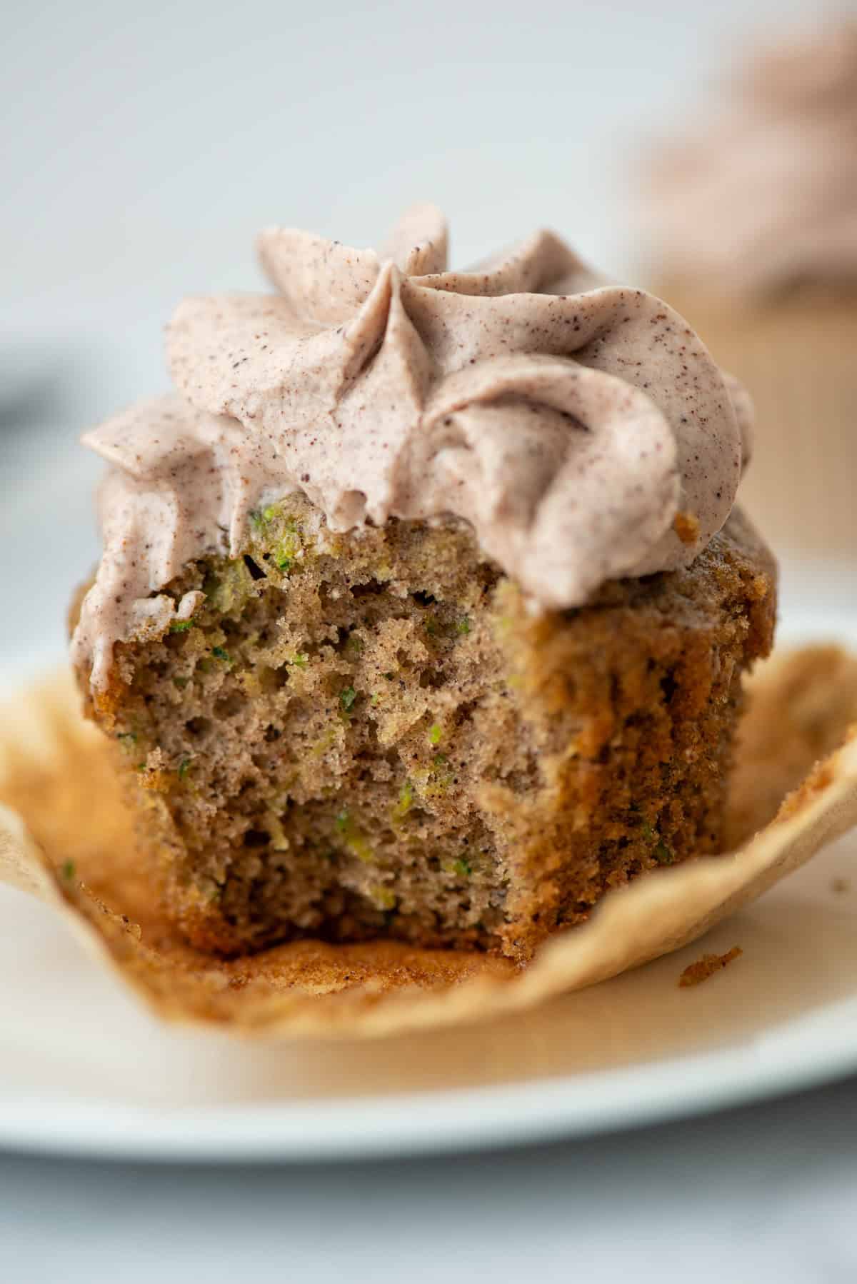 Photo of a zucchini cupcake on a plate with a bite taken out of it