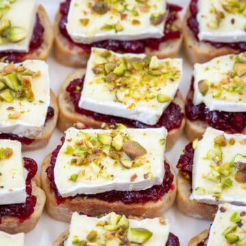Overhead close up photo of cranberry brie crostini on a serving platter