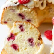 Fresh strawberry cake with white frosting, topped with fresh berries and whipped cream.