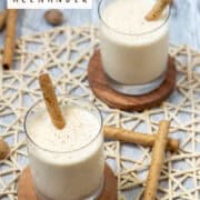 Frozen Brandy Alexander cocktails garnished with ground nutmeg and Pirouette cookies. Photo has a Frozen Brandy Alexander title overlay and www.nestlevelbaker.com overlay at the bottom