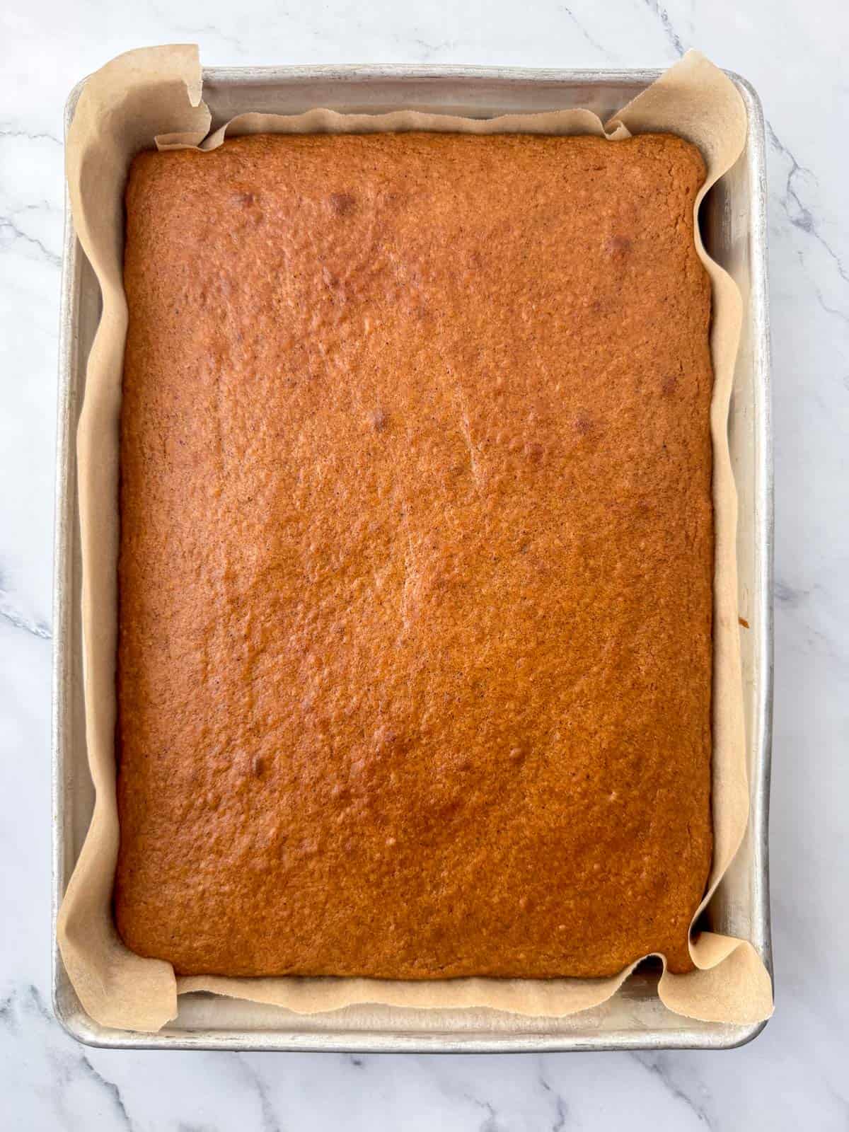Overhead photo of a baked GF pumpkin bar cake that's cooled and ready to be frosted