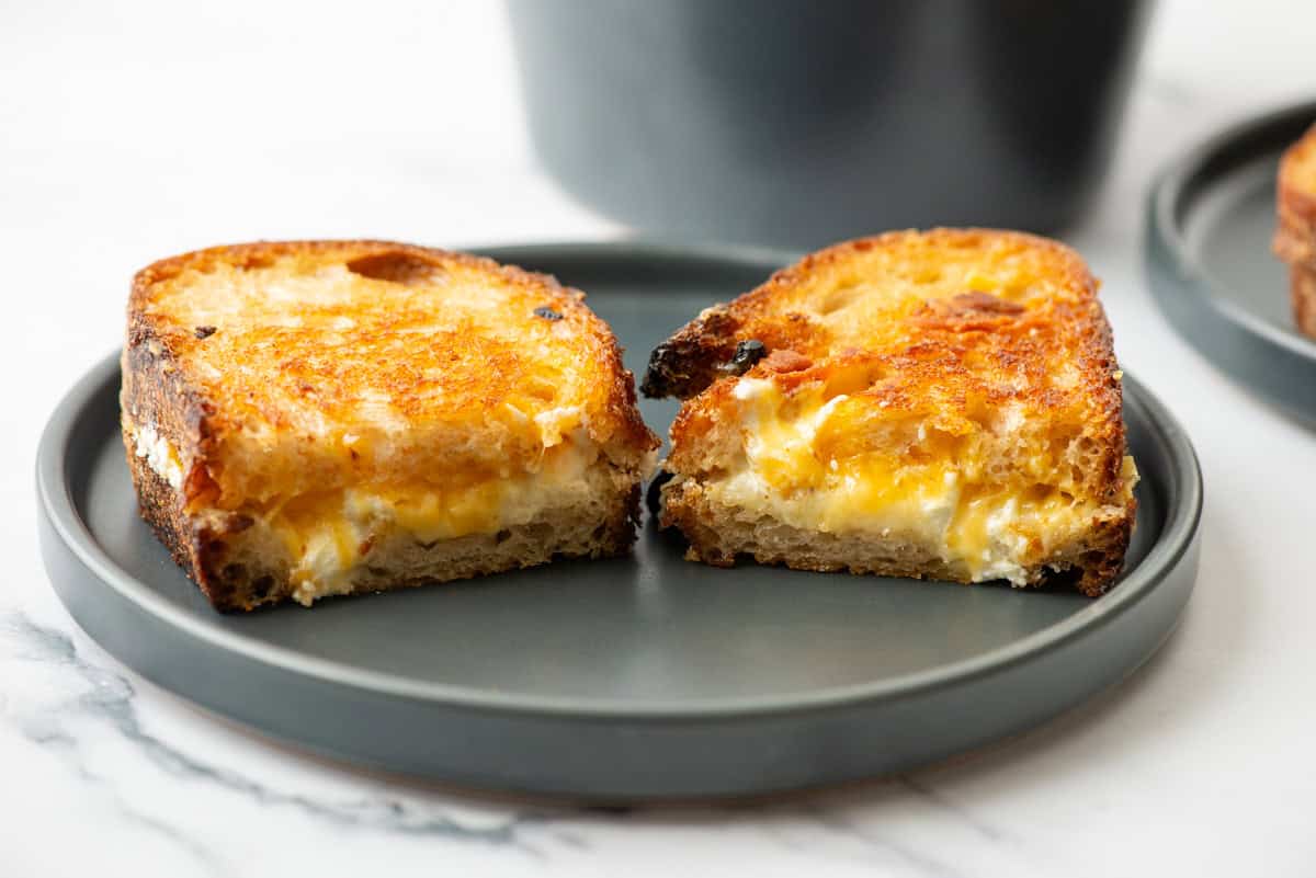 Side view of a cut grilled cheese sandwich on a plate that's been turned so that you can see the inside of the sandwich