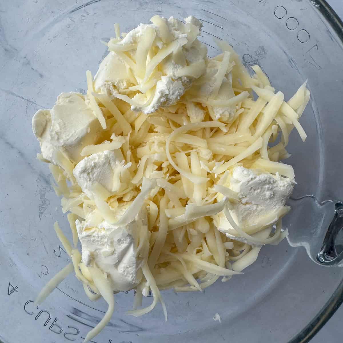 Step 1: Add cream cheese and cheddar cheese to a microwave safe bowl