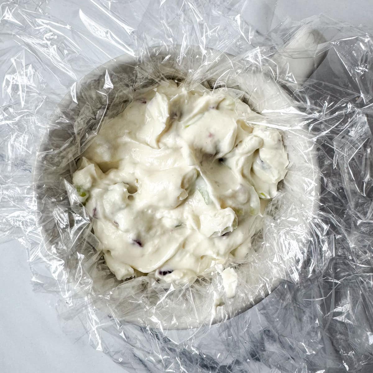 Step 3: Stir in chopped green onions, half of the chopped cranberries, garlic powder, salt and umami powder (optional). Add to cup lined with plastic wrap.